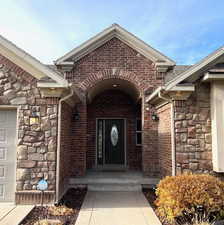 Doorway to property featuring stone siding and brick siding