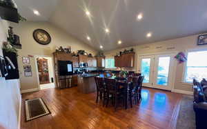 Dining area featuring high vaulted ceiling, hardwood floors, and recessed lighting