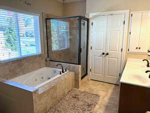 Master bathroom featuring double vanity, ceramic tile shower and a jetted soaking tub.