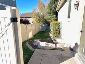 View of side yard showing man door to garage.