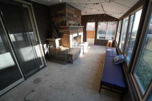 Sunroom / solarium featuring unfinished concrete flooring and wooden walls