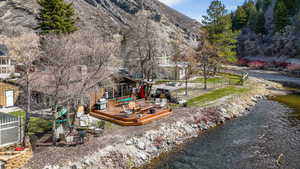 View of home's community featuring a deck with water view, a patio area, and an outdoor fire pit
