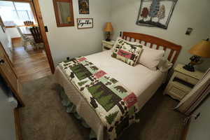 Bedroom with dark colored carpet and dark wood-style floors