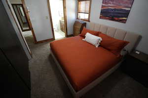 Bedroom with light colored carpet and ensuite bath