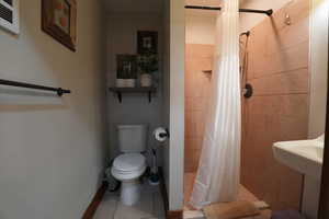 Full bathroom featuring a shower stall and tile patterned floors