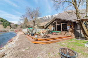 Deck with a fire pit and a water and mountain view