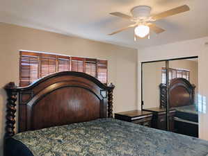 Bedroom featuring a ceiling fan and a closet