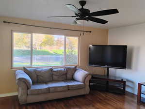 Living room with dark wood-style floors and ceiling fan