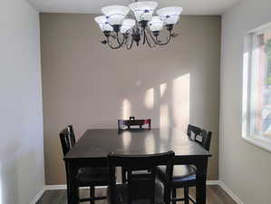 Dining room featuring dark wood-style flooring and a chandelier