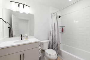 Bathroom featuring vanity and shower / bathtub combination with curtain