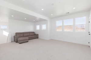 Unfurnished living room with recessed lighting and light colored carpet