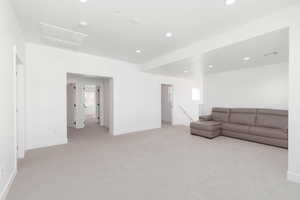 Living area with light colored carpet and recessed lighting
