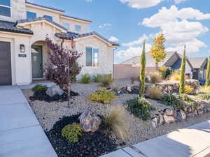 View of front of house featuring stone siding, stucco siding, and a tiled roof