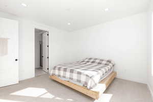 Bedroom with light colored carpet and recessed lighting