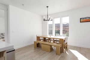 Dining space featuring light wood-style flooring and a chandelier