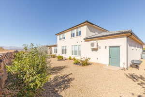 Rear view of property with stucco siding and a tiled roof