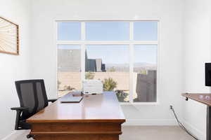 Carpeted home office with healthy amount of natural light