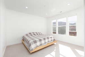Bedroom with a mountain view, recessed lighting, and carpet floors