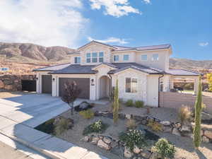 Mediterranean / spanish home with a mountain view, stone siding, driveway, stucco siding, and a tiled roof