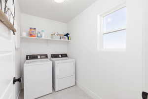 Washroom featuring separate washer and dryer and baseboards