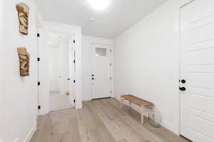 Foyer entrance featuring light wood-style flooring and baseboards