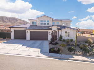 Mediterranean / spanish home with stucco siding, concrete driveway, stone siding, a tiled roof, and a garage