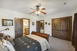 Bedroom featuring carpet flooring, a closet, a ceiling fan, and ensuite bathroom
