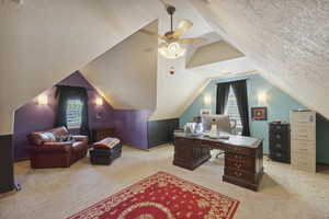 Office featuring light carpet, lofted ceiling, ceiling fan, and a textured ceiling