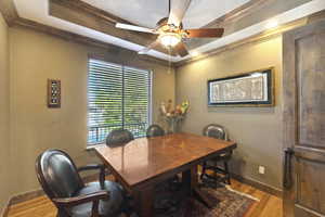 Dining room with wood finished floors, ornamental molding, and a ceiling fan