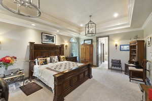 Bedroom featuring a chandelier, a tray ceiling, ornamental molding, light colored carpet, and recessed lighting