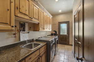 Laundry area featuring stone tile flooring, independent washer and dryer, cabinet space, recessed lighting, and a textured ceiling