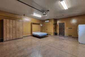 Garage featuring freestanding refrigerator and a garage door opener