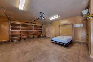 Garage with a wall mounted AC and a garage door opener