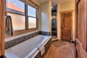 Full bath with a jetted tub and a shower stall