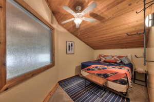 Bedroom featuring wood ceiling, vaulted ceiling, carpet flooring, and a ceiling fan