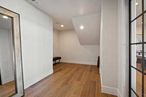 Additional living space with light wood-style floors and recessed lighting
