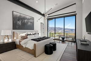 Bedroom with wood finished floors, access to outside, lofted ceiling, recessed lighting, and a chandelier