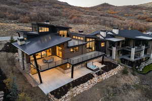 Back of property featuring a chimney, a patio, a standing seam roof, and a metal roof