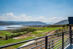 View of mountain backdrop featuring a nearby body of water and a local golf course