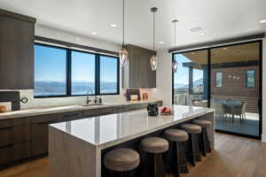 Kitchen with a mountain view, modern cabinets, light stone countertops, and recessed lighting