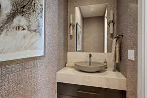Bathroom with vanity and tile walls