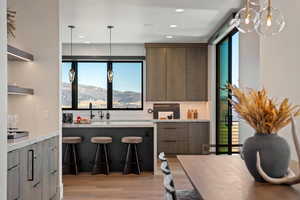 Kitchen featuring decorative light fixtures, modern cabinets, plenty of natural light, and recessed lighting