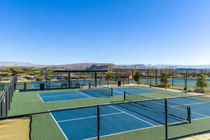 View of tennis court with community basketball court and a mountain view