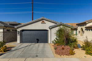 View of front facade featuring stucco siding, concrete driveway, a garage, and a tiled roof