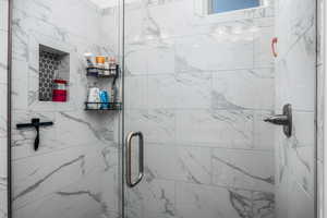Bathroom featuring a marble finish shower
