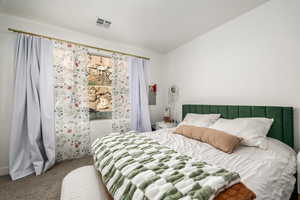 Bedroom with carpet floors and lofted ceiling