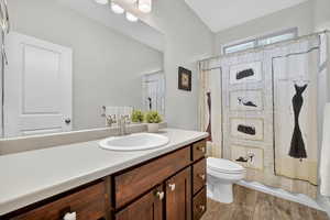 Full bathroom with light wood-style flooring, vanity, and shower / bathtub combination with curtain
