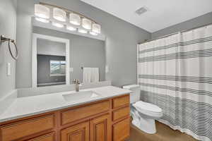 Full bath featuring a shower with curtain, vanity, and light wood-style flooring