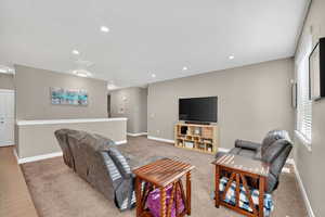 Carpeted living room with a textured ceiling and recessed lighting