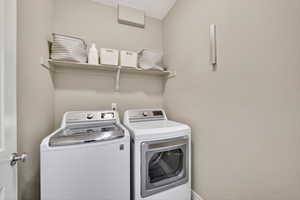 Laundry area featuring separate washer and dryer and baseboards